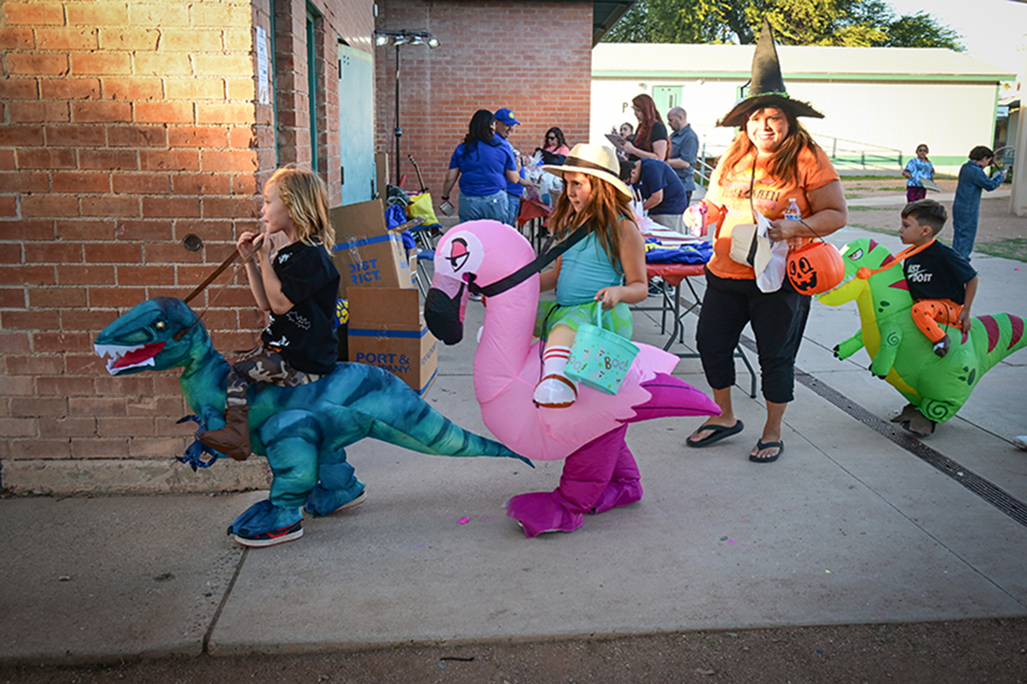 Students walk in their inflatable dinosaur and flamingo costumes