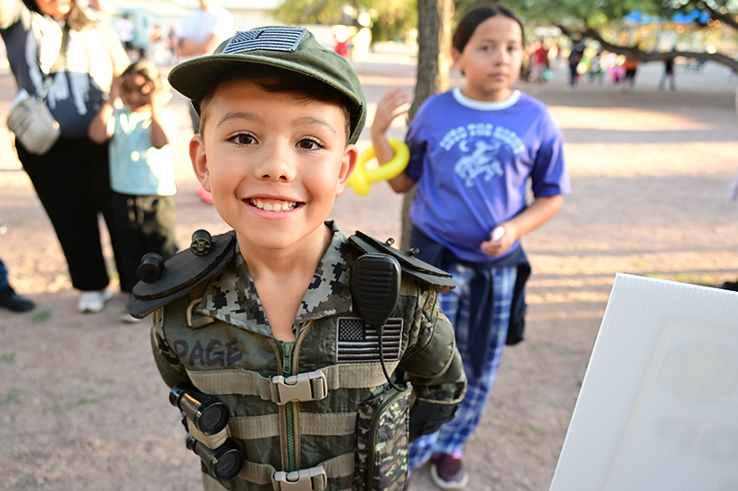 A little boy in a military uniform costume smiles