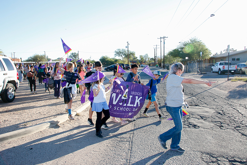 A group of students and staff march around the school for Ruby Bridges Walk to School Day
